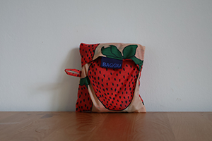 A strawberry-print bag tucked into a small matching pouch.