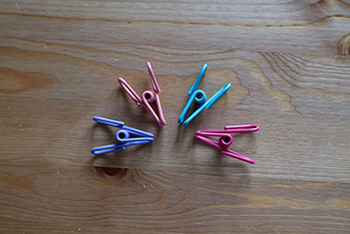 Four multi-colored wire clips arranged in a semi-circle
